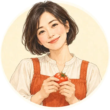 小町ひよりのイラスト。ボブの髪で、生成りのブラウスにオレンジのエプロン。両手でトマトを持って笑っている